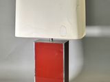 une image représentant une lampe rouge et blanche posée sur une table