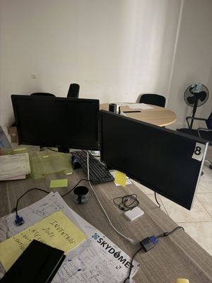 un bureau sur lequel sont posés deux écrans et un ordinateur portable