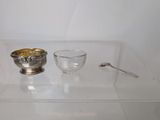 a silver bowl and a silver spoon on a glass table