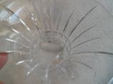 une personne tenant un bol en verre transparent percé d'un trou