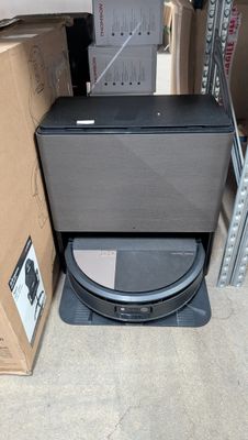 a black toilet sitting in a room next to a cardboard box