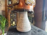 a vase with a helmet on top of it sitting on a table