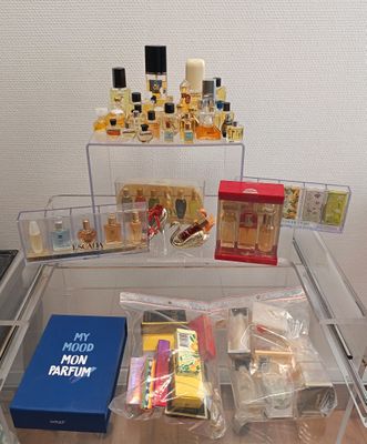 une table en verre sur laquelle sont posés de nombreux parfums