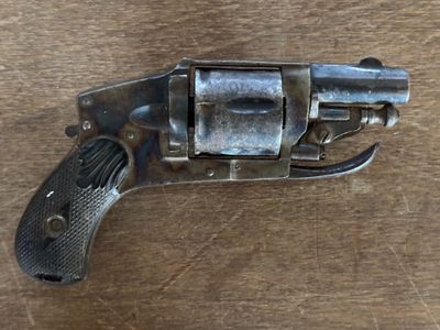 un petit pistolet posé sur une table en bois