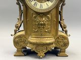 a gold clock that is sitting on a table