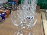 Plusieurs verres à vin vides sont posés sur une table devant un mur vert.