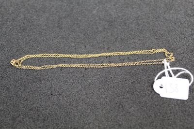 a gold chain with a small white tag on it