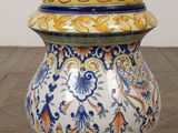 a large vase with a colorful design on it on a wooden floor