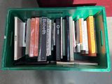 many books in a green box on the floor
