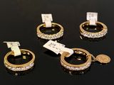 three gold rings with diamonds on a black surface with a price tag