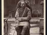 photographie en noir et blanc d'un vieil homme assis sur une chaise à côté d'une femme