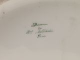 a close up of a white plate with green writing on it