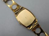 a close up of a gold watch on a white surface