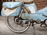a blue motorcycle with a basket on the back of it