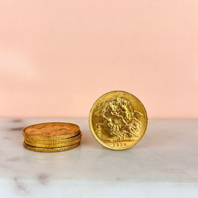 two gold coins sitting next to each other on a marble surface