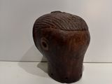a small wooden sculpture of a man ' s head on a table
