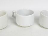 trois tasses à café blanches sont alignées sur une surface blanche