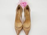 a close up of a pair of nude colored shoes with a flower on top