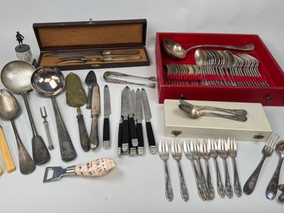 a lot of silverware on a table with a red box