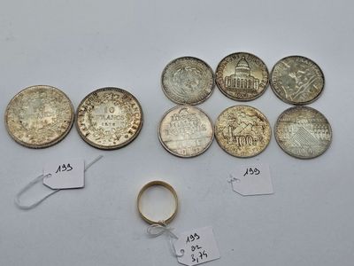a close up of a bunch of coins and a ring on a table