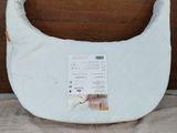 a baby bib with a label on it on a bed