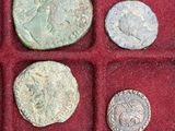several ancient roman coins are in a red box on a table