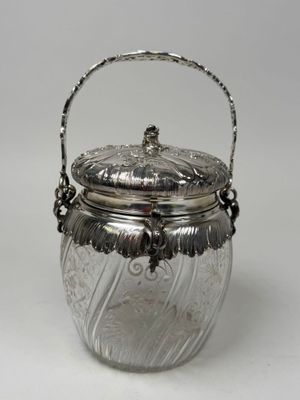 a silver plated jar with a handle and a handle