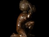 bronze statue of a kneeling boy with a ball on his head