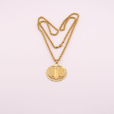 un collier en or avec un médaillon et une chaîne sur fond blanc
