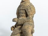 une image représentant la statue d'un homme assis sur un bloc de bois