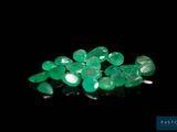 a close up of a bunch of green gems on a black surface