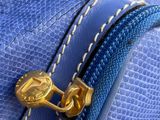 a close up of a blue purse with a gold zipper