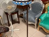 several chairs and a table with a lamp on it in a room