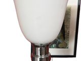 a lamp that is sitting on a table with a picture on the wall