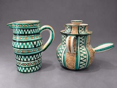 deux vases verts et blancs posés l'un à côté de l'autre sur une surface grise