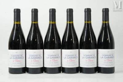 six bottles of red wine are lined up on a table