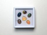 plusieurs pierres de différentes couleurs dans une boîte blanche posée sur une surface blanche