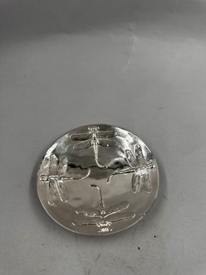 un plateau en argent orné d'une image, posé sur une table