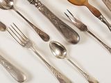 many spoons, forks, and spoon spoons laid out on a table