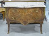 une commode avec un plateau en marbre dans une pièce