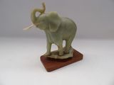 statue d'un éléphant doté d'une longue défense, posée sur un socle en bois