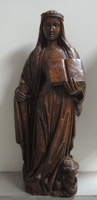 une statue représentant une femme tenant un livre et un chien
