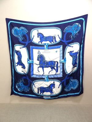une photo d'une écharpe bleue et blanche représentant un cheval, accrochée au mur