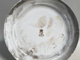 une assiette en argent ornée d'un emblème en or