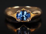 Gros plan sur une bague en or ornée d'un saphir bleu