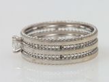 a close up of a stack of silver rings on a white surface