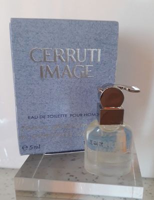 un flacon de parfum posé sur une table à côté d'un livre