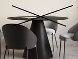 quatre chaises disposées autour d'une table sur laquelle se trouve une horloge