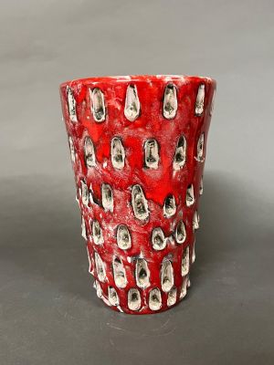 un gobelet rouge orné d'un motif représentant des chats