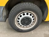 a close up of a tire on the side of a yellow bus